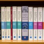 Collection of books from the Probabilistic Intelligent Robotics and Autonomous Agents series displayed on a bookshelf with robotic equipment in the background